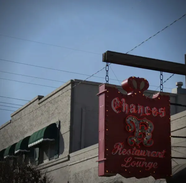 The red Chances R sign with its crown, hanging over the sidewalk on West 5th Street